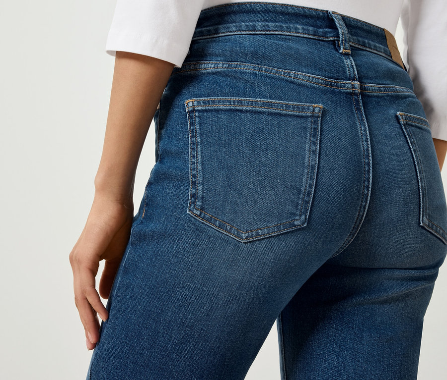 Detailaufnahme der Rückseite einer blauen Jeans an einer Person.