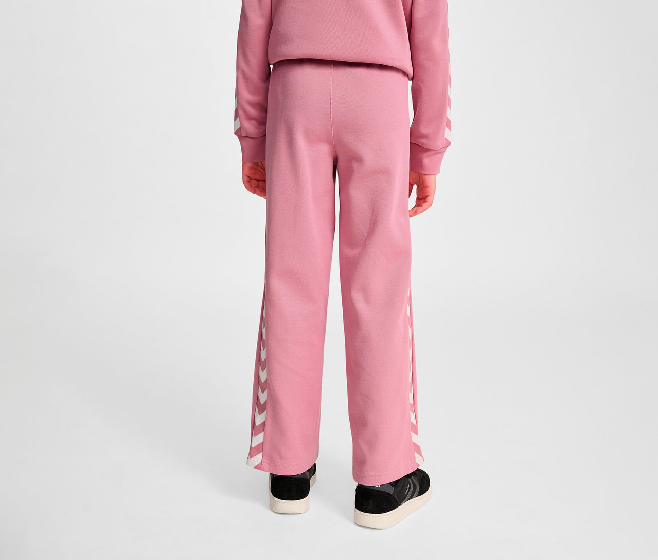 Rückansicht eines Kindes, das eine HUMMEL HMLJR Archive Wideleg Poly Hose trägt.