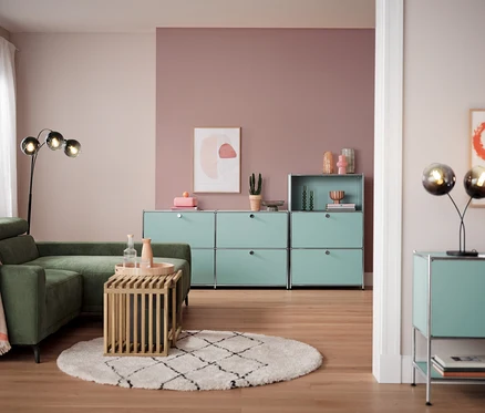Wohnzimmer mit Ecksofa, Holztisch und Bogenleuchte mit Rauchglasschirmen.