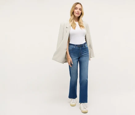 Frau trägt eine »Lara City« Straight Fit Jeans von Angels, ein weißes T-Shirt, einen Blazer und Turnschuhe.
