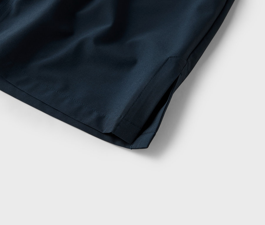 Nahaufnahme der Tasche einer marineblauen Shorts vor einem weißen Hintergrund.