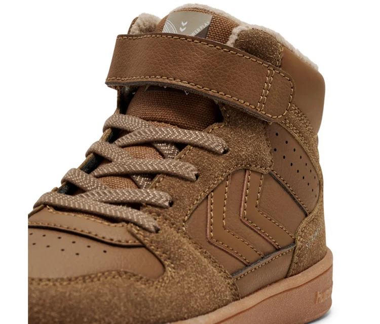 Brauner hummel® St Power Play Mid Wt Jr Sneaker mit Schnürsenkeln, Klettverschluss und warmem Futter.