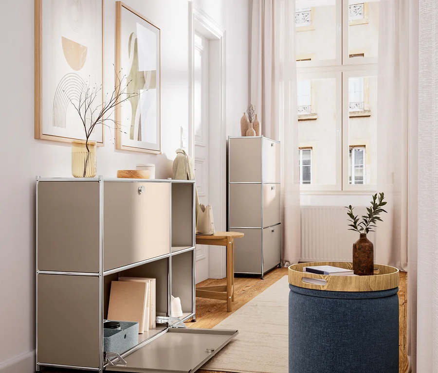 Heller Raum mit Holzboden. Links beiger modularer Schrank mit offenem Fach, Büchern und Deko. Rechts ein Hocker aus Massivholz und ein blauer Pouf mit Holztablett und Pflanze.