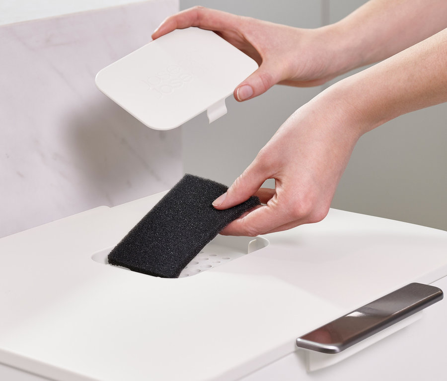 Eine Frau legt einen Filter in einen Recycling-Abfalleimer von Joseph Joseph.