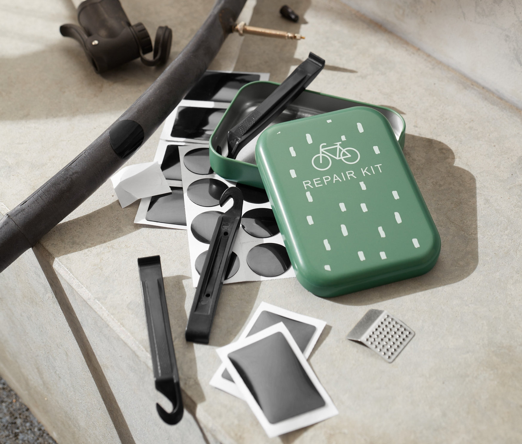 Ein Fahrradreparatur-Set liegt auf Stufen neben einer Pumpe und einem Schlauch.