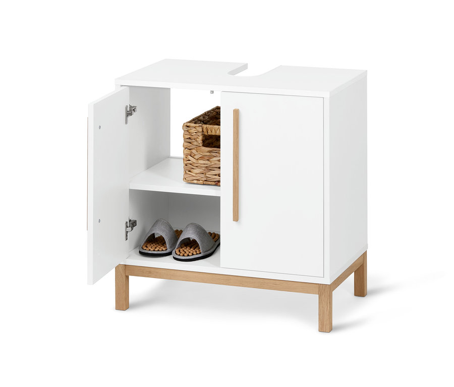 Ein offener, weißer Eklund Waschbeckenunterschrank mit Korb und Hausschuhen im Inneren.