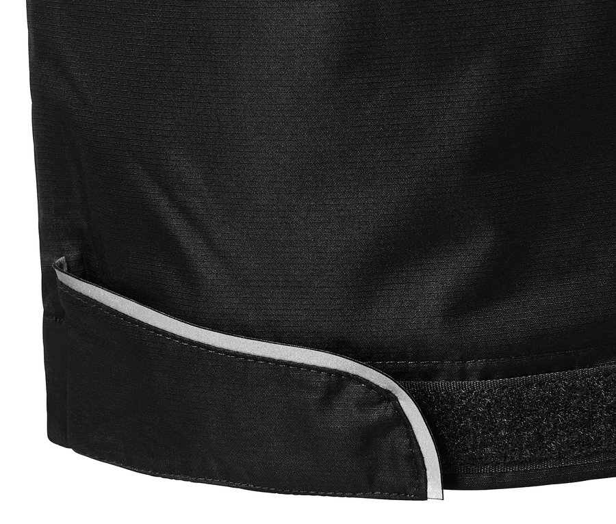 Detailaufnahme einer schwarzen Regenhose mit reflektierendem Saum und Klettverschluss.
