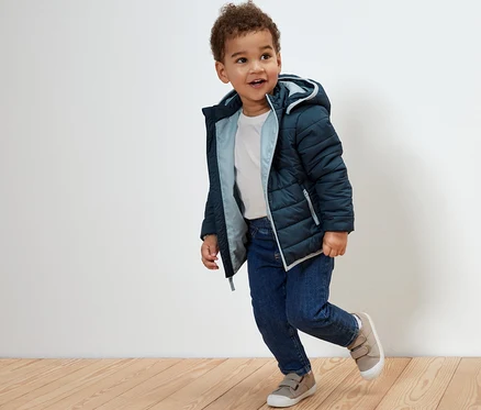 Junge trägt eine marineblaue Kinder-Steppjacke.