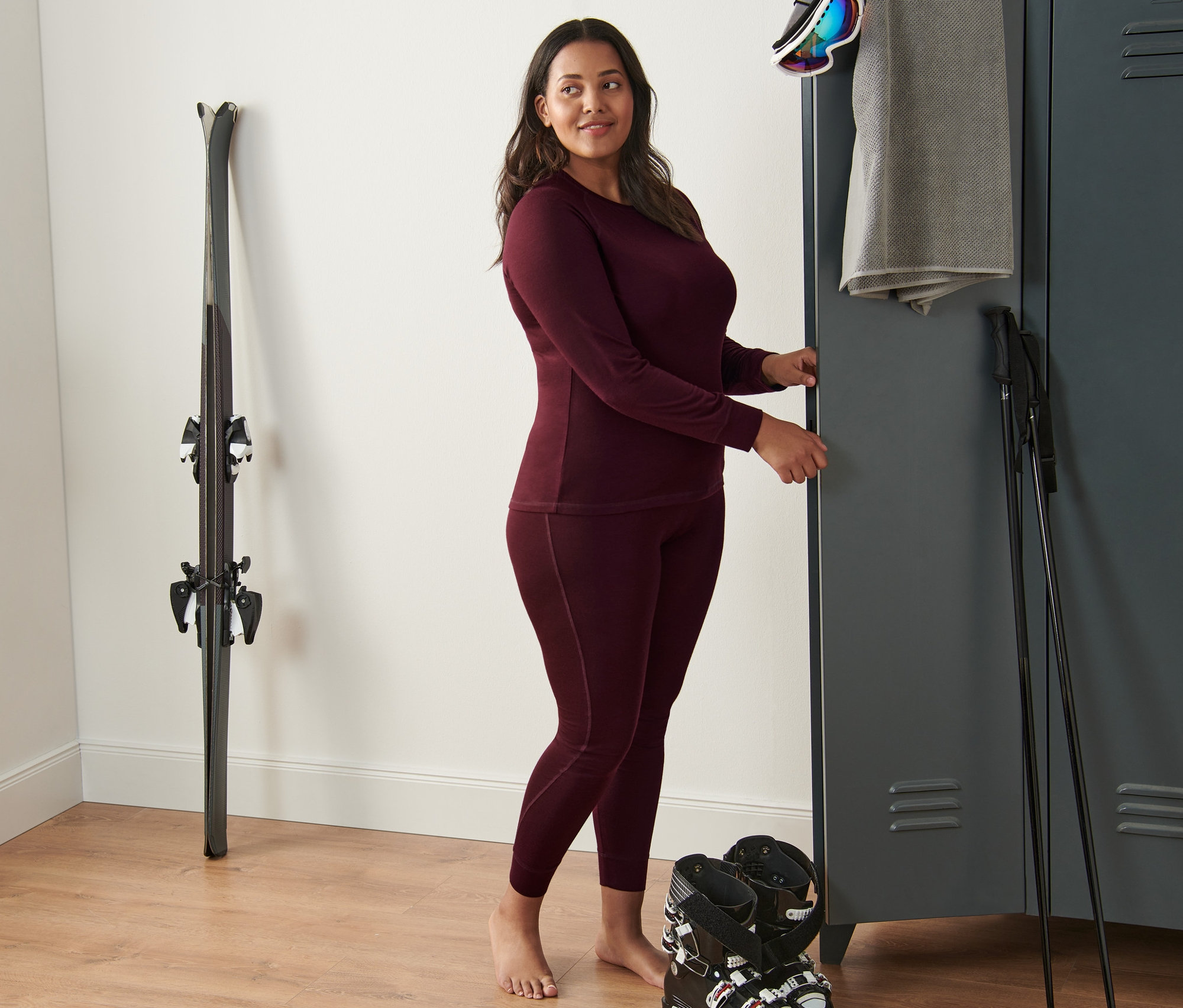 Frau steht und trägt ein rotes Funktionsshirt und eine Funktionsunterhose mit Merinowolle.