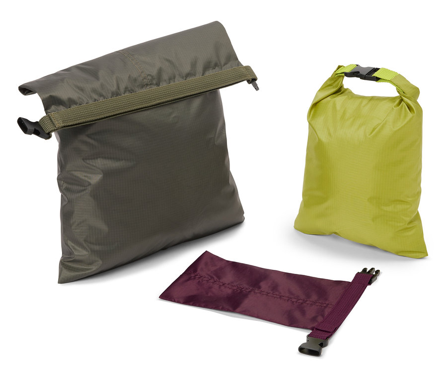 Drei wasserdichte Packsäcke in Olivgrün, Limettengrün und Violett liegen auf einem weißen Hintergrund.