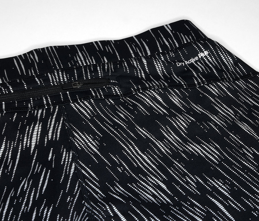 Detailaufnahme von schwarzen Leggings mit weißem Linienmuster und Reißverschlusstasche.