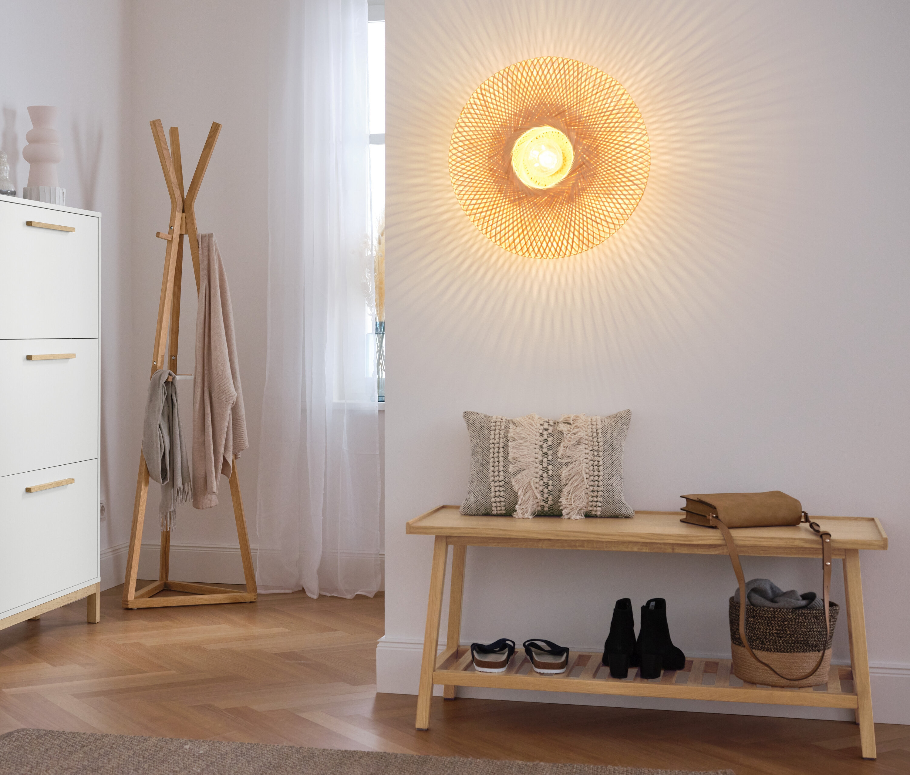 Flur mit Schuhschrank, Garderobenständer und Sitzbank mit Ablage.