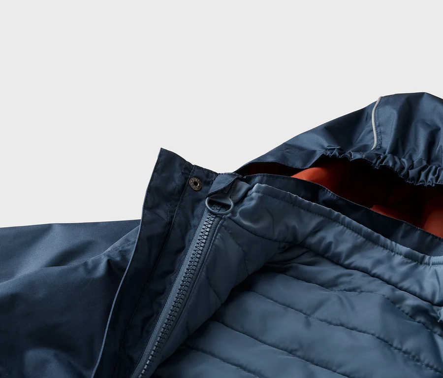 Nahaufnahme einer geöffneten, marineblauen Jacke mit Kapuze, Reißverschluss und gestepptem Innenfutter.