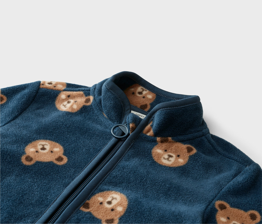 Nahaufnahme einer marineblauen Fleecejacke mit Reißverschluss und Bärenmuster.
