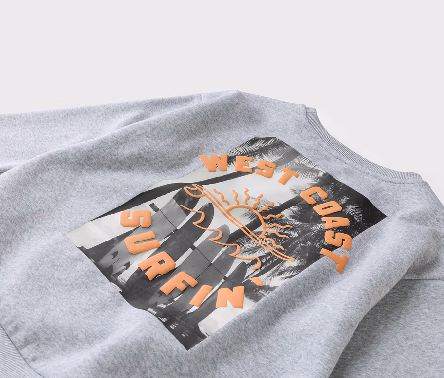 Graues Sweatshirt mit einem Aufdruck von Surfbrettern, Palmen und dem Schriftzug 'West Coast Surfing'.
