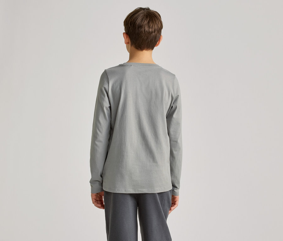 Rückansicht einer Person mit kurzen braunen Haaren, die ein graues Langarmshirt und graue Hosen vor einem hellgrauen Hintergrund trägt.