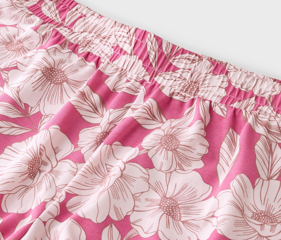 Nahaufnahme eines pinkfarbenen Stoffes mit Blumenmuster und elastischem Bund.