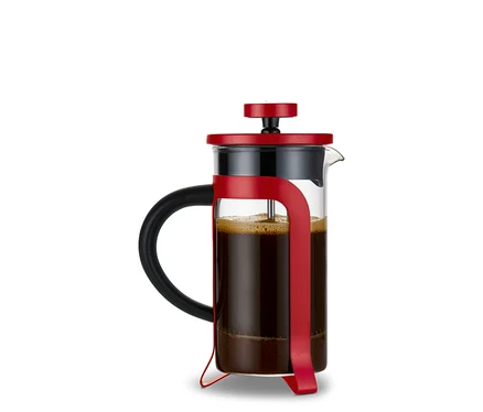 Eine rote Siebstempelkanne mit 300 ml Fassungsvermögen und 2 Tassen, gefüllt mit Kaffee. Im Hintergrund ist ein Geschenkset "Liebe-To-Go" zu sehen.
