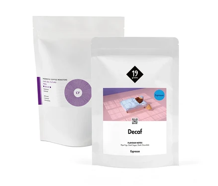 Zwei weiße Verpackungen des "Entkoffeiniertes Espresso Probierpaket "Duo-Decaf" - 2x 250 g Ganze Bohne" sind sichtbar.