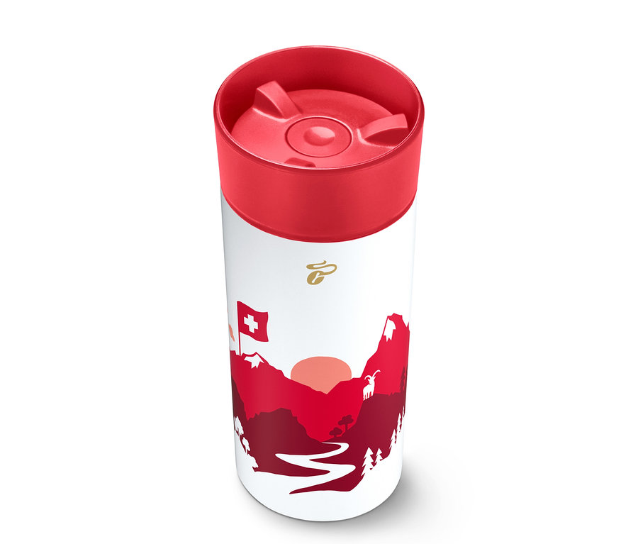 Weißer zylindrischer Thermobecher mit rotem Deckel, verziert mit einer rot-weißen Grafik von Bergen, einer untergehenden Sonne, einer Schweizer Flagge und einer Ziege, mit einem goldenen Logo oben.