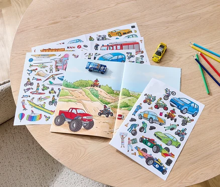 Auf einem Tisch liegen ein geöffnetes Stickerbuch »Fahrzeuge« und Buntstifte.