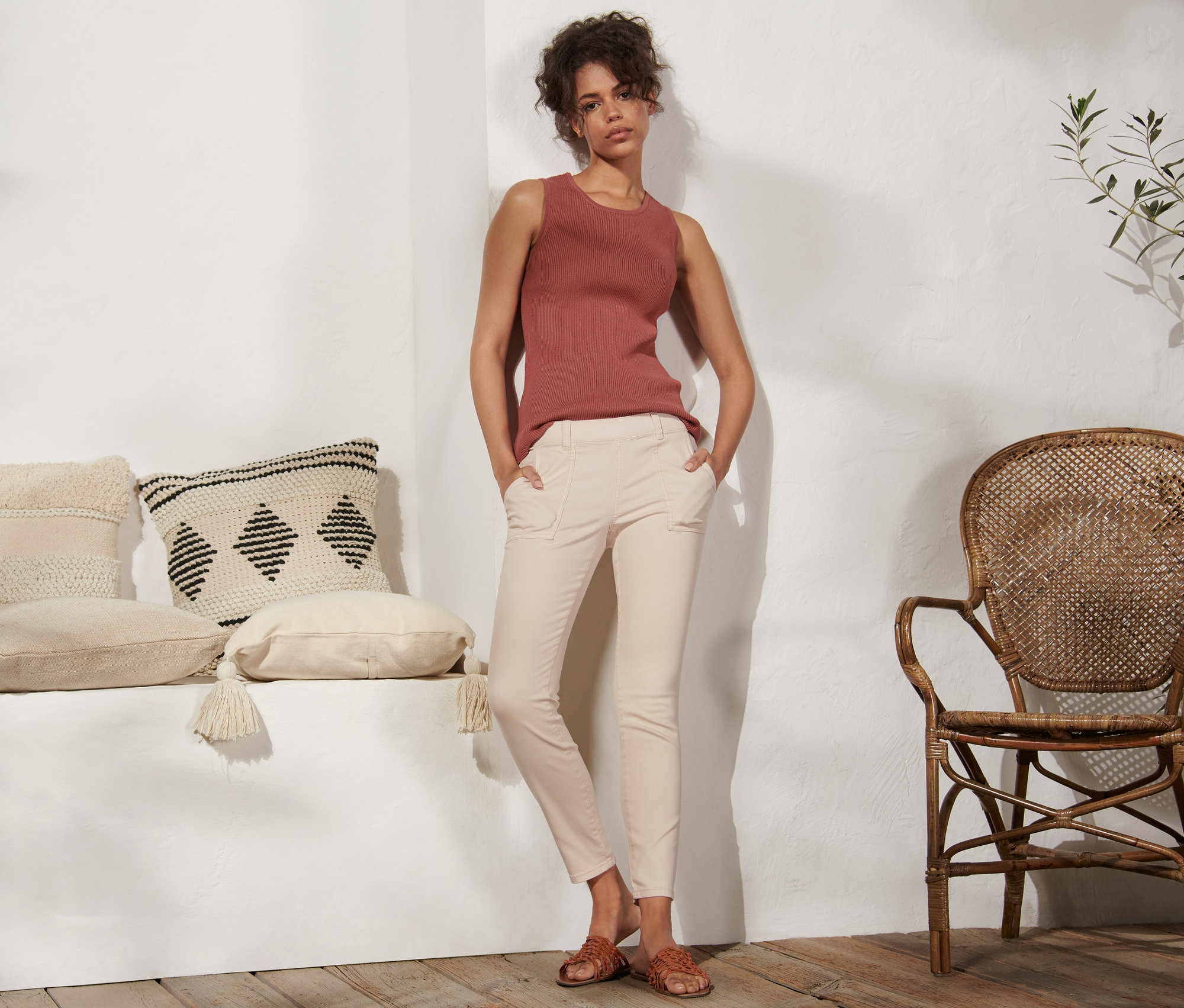 Eine Frau steht mit den Händen in den Taschen ihrer Treggings.