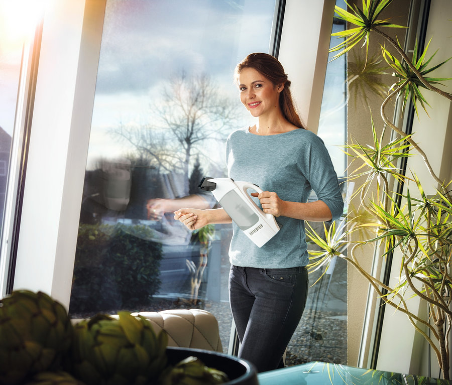Frau putzt Fenster mit »DRY &amp; Clean Classic« Fenstersauger.