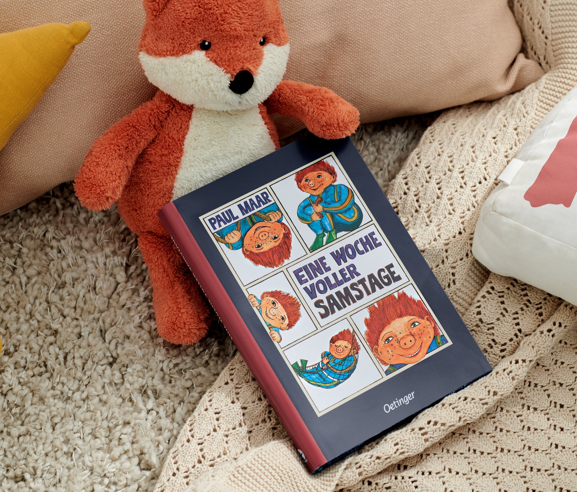 Ein Stofffuchs liegt neben dem Buch »Das Sams – eine Woche voller Samstage« und Kissen.