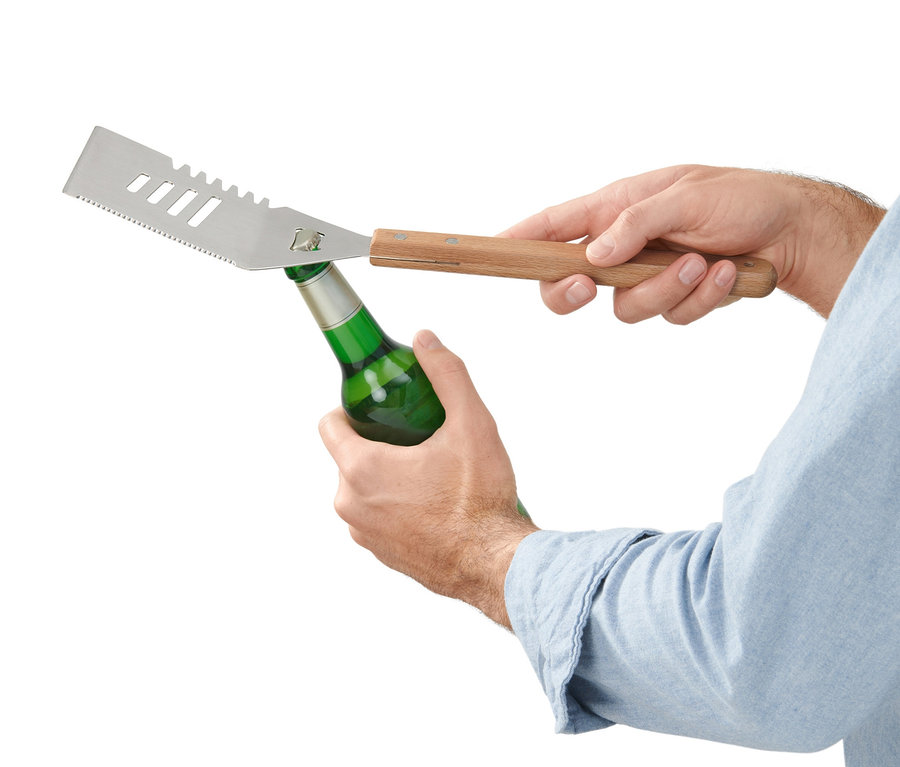 Mann öffnet eine grüne Flasche mit einem BBQ-Multitool.