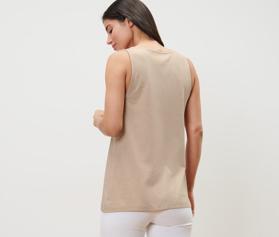 Frau von hinten trägt ein beige meliertes Top mit Knopfleiste und weiße Hose.