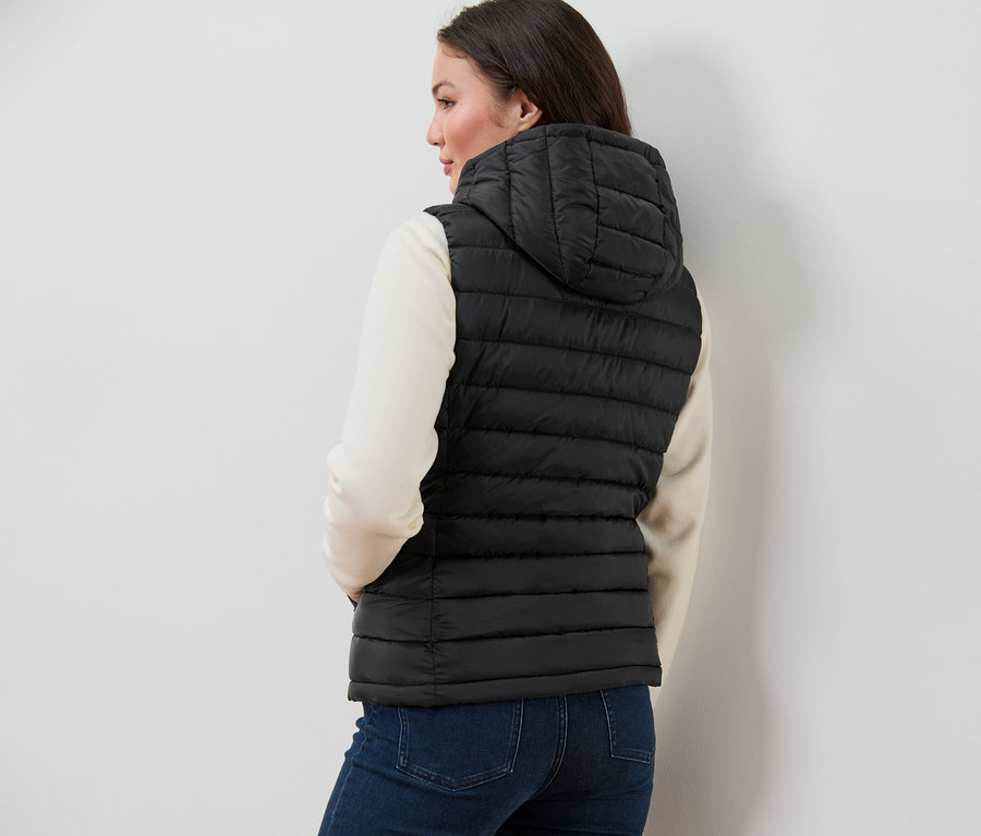 Frau trägt eine Steppweste mit Kapuze.