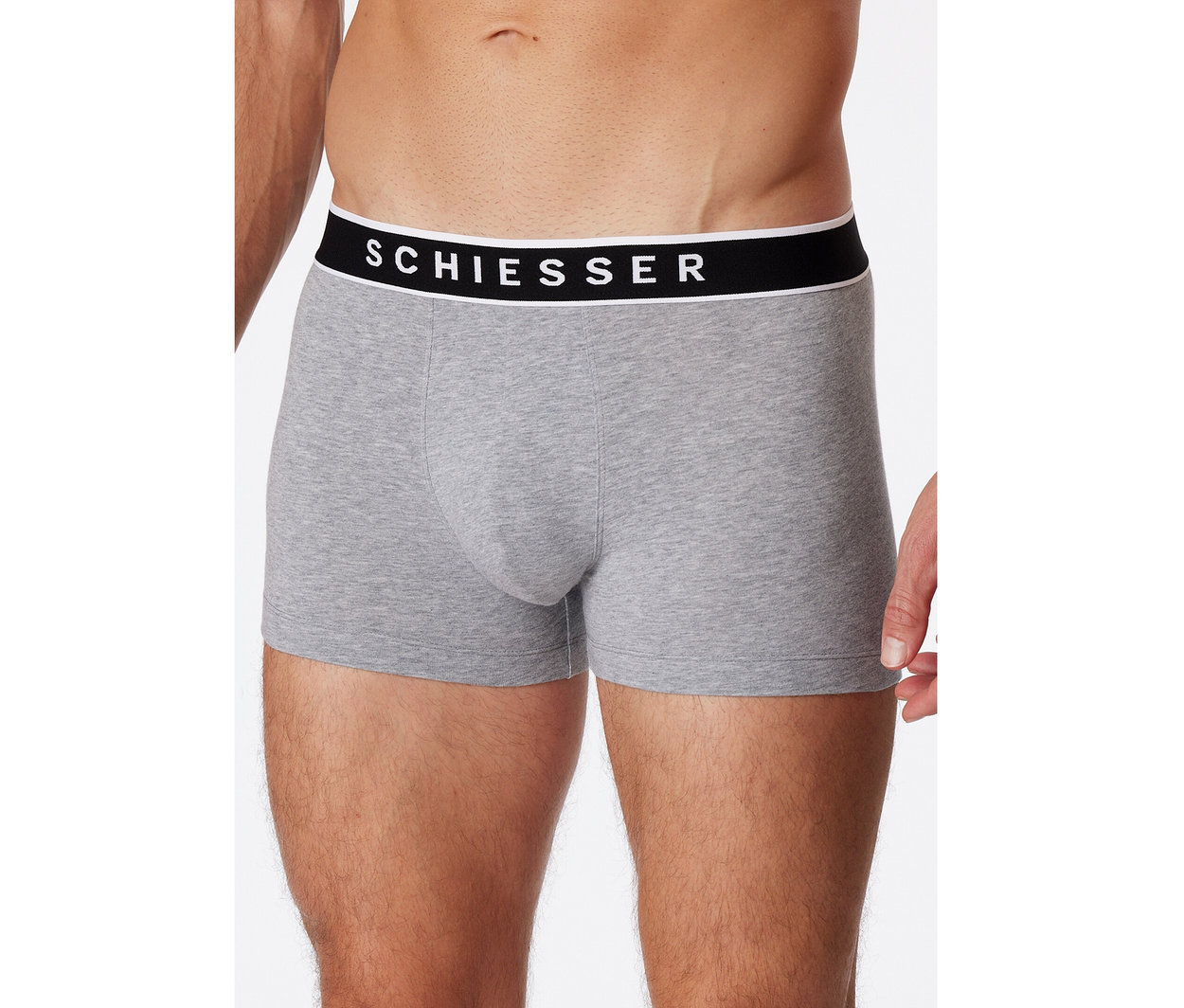 Mann trägt graumelierte SCHIESSER Shorts mit schwarzem Bund und weißem Logo.