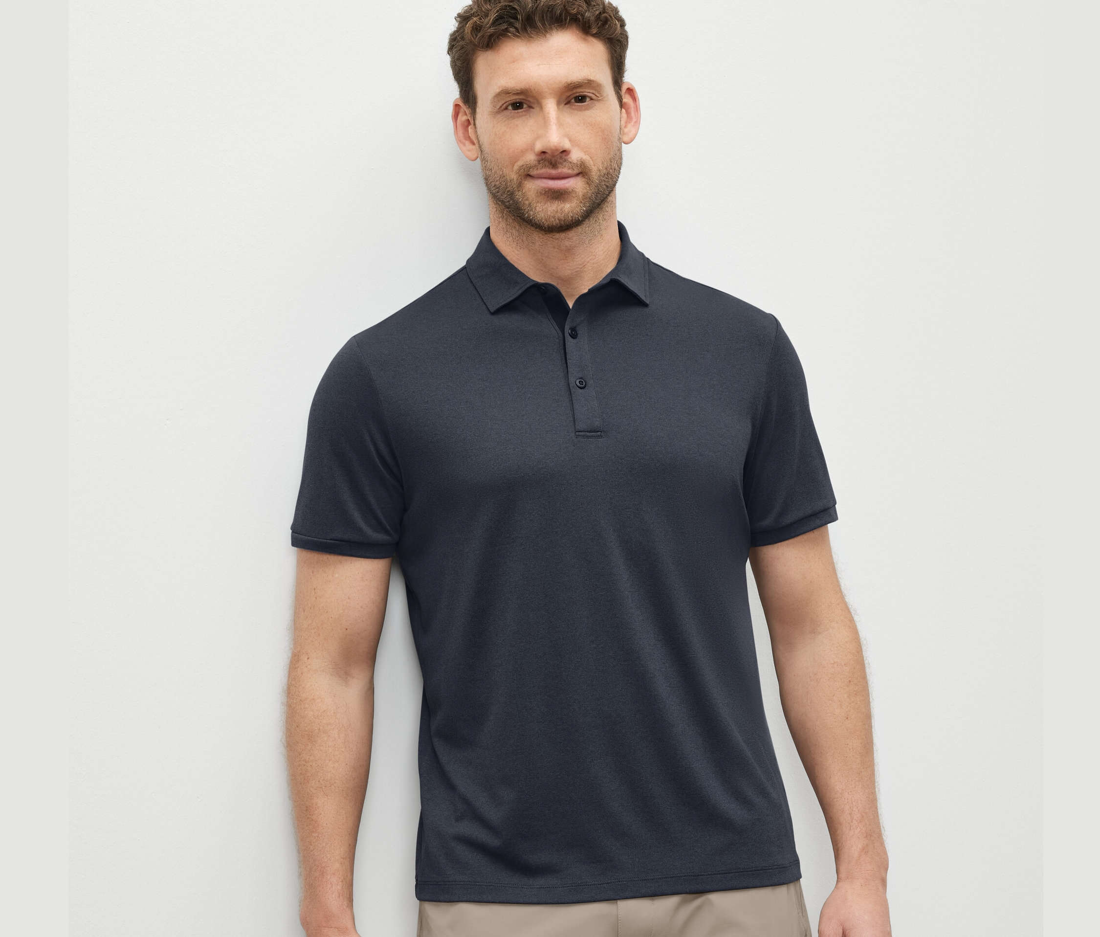 Mann trägt ein blaues Funktions-Poloshirt.