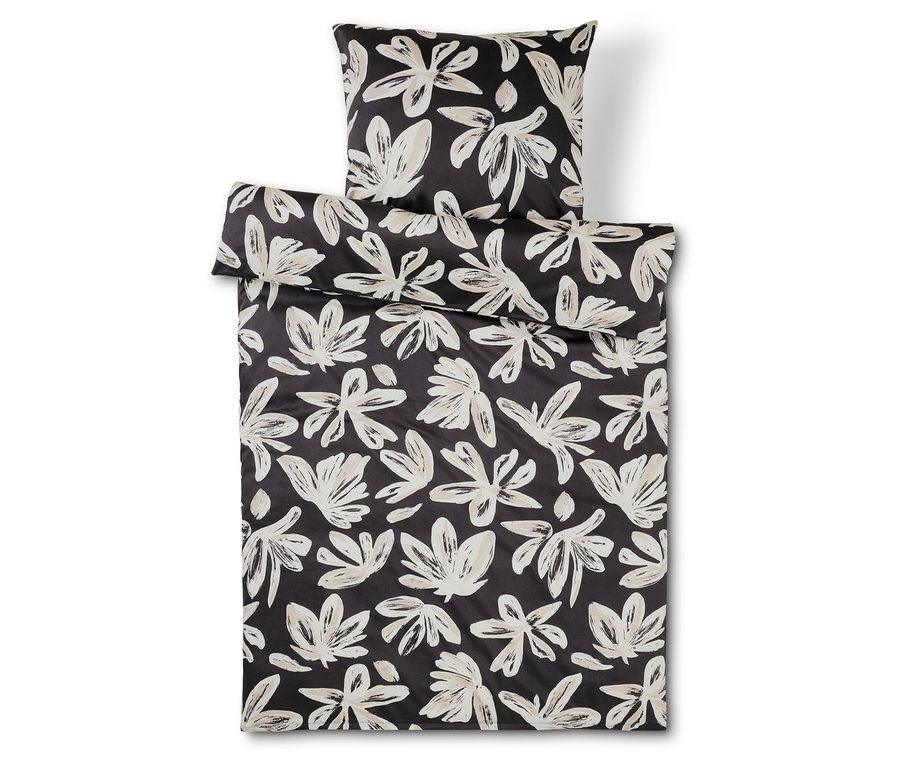 Schwarz-weisse Bettwäsche und Kissen mit Blumenmuster.