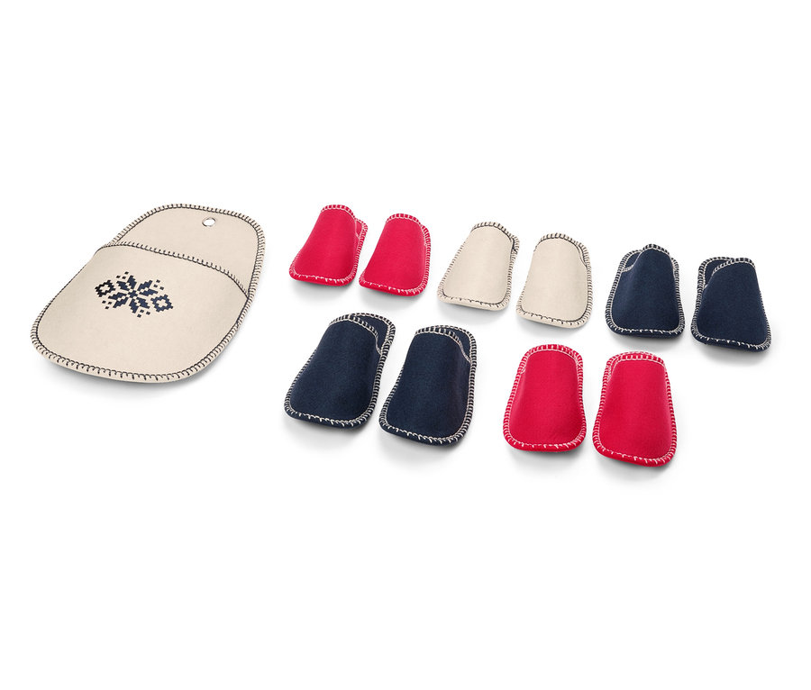 Stricknadel Etui mit Stickerei neben einem Set aus roten, cremefarbenen und blauen Stricknadelspitzen.