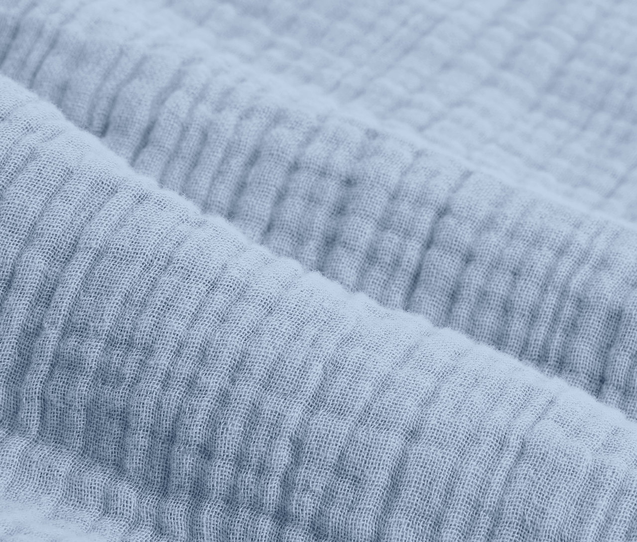 Nahaufnahme von hellblauer Musselin-Bettwäsche in Normalgröße.