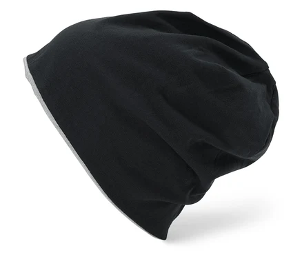 Eine schwarze, gestrickte Mütze mit grauem Futter liegt auf einem weißen Hintergrund.