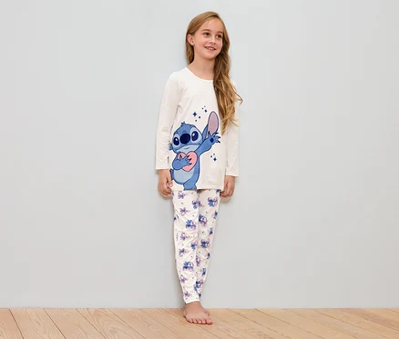 Mädchen trägt einen weißen Schlafanzug mit Stitch-Motiv.