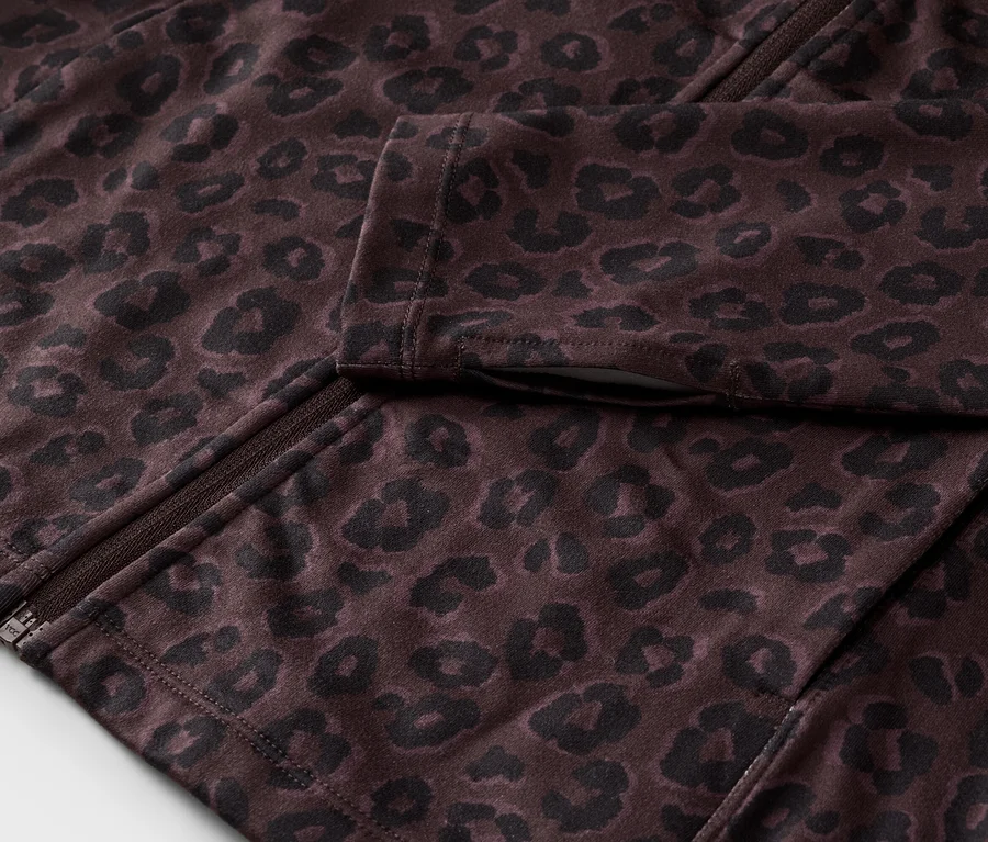 Nahaufnahme einer teilweise geöffneten, dunkelbraunen Jacke mit schwarzem Leopardenmuster und Reißverschluss.