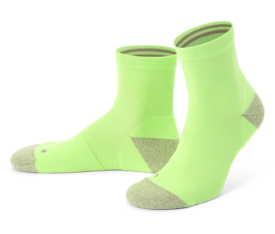 Zwei hellgrüne Socken mit grauen Zehen und Bündchen stehen auf einem weißen Hintergrund.