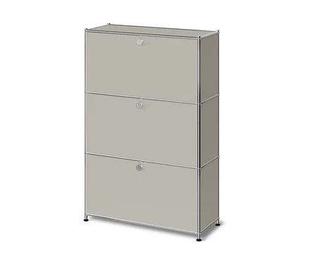 Helles beiges Modulschrank mit drei Klapptüren und einem Chromrahmen, auf kurzen schwarzen Füßen stehend.