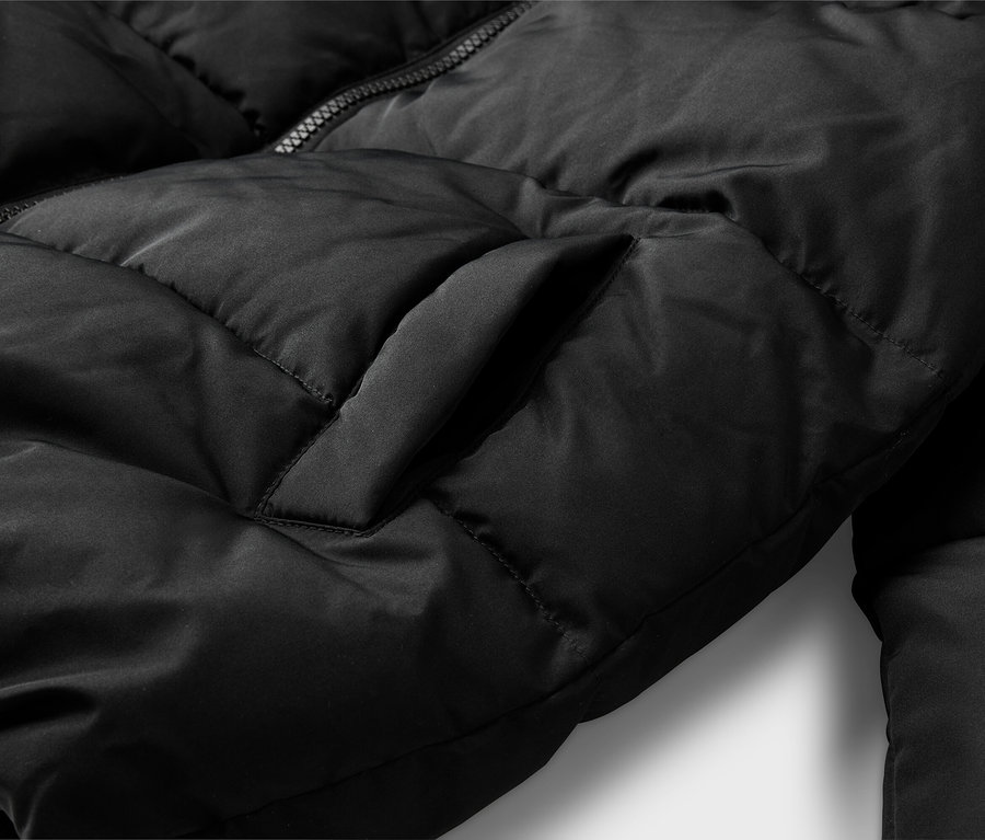 Nahaufnahme einer schwarzen Steppjacke mit gesteppter Textur, einem teilweise sichtbaren Reißverschluss und einer vertikalen Seitentasche.