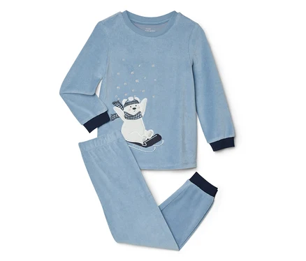 Hellblauer Velours-Pyjama mit langärmeligem Oberteil und langer Hose. Das Oberteil zeigt einen gestickten weißen Eisbären auf einem schwarzen Schlitten, der eine gestreifte Mütze und einen Schal trägt, umgeben von silbernen Schneeflocken. Die Bündchen an Ärmeln und Hosenbeinen sind dunkelblau.
