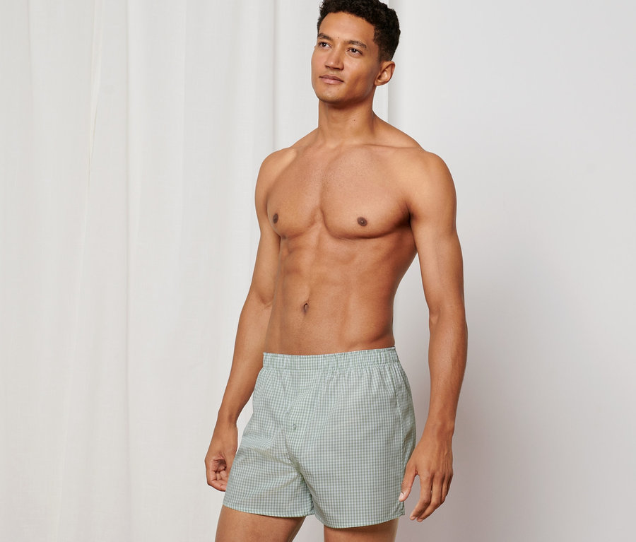 Mann posiert ohne Hemd und trägt 2 Web-Boxershorts.