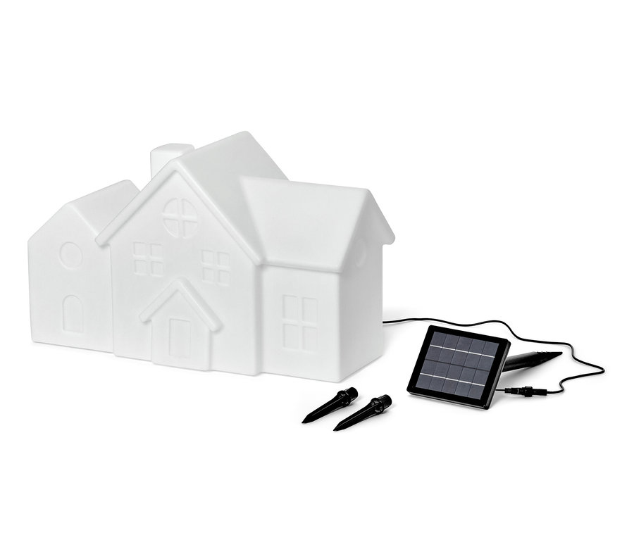 Eine weiße Solar-Outdoorleuchte in Form eines Hauses, ein Solarpanel und zwei Befestigungsstifte sind auf einem weißen Hintergrund dargestellt.