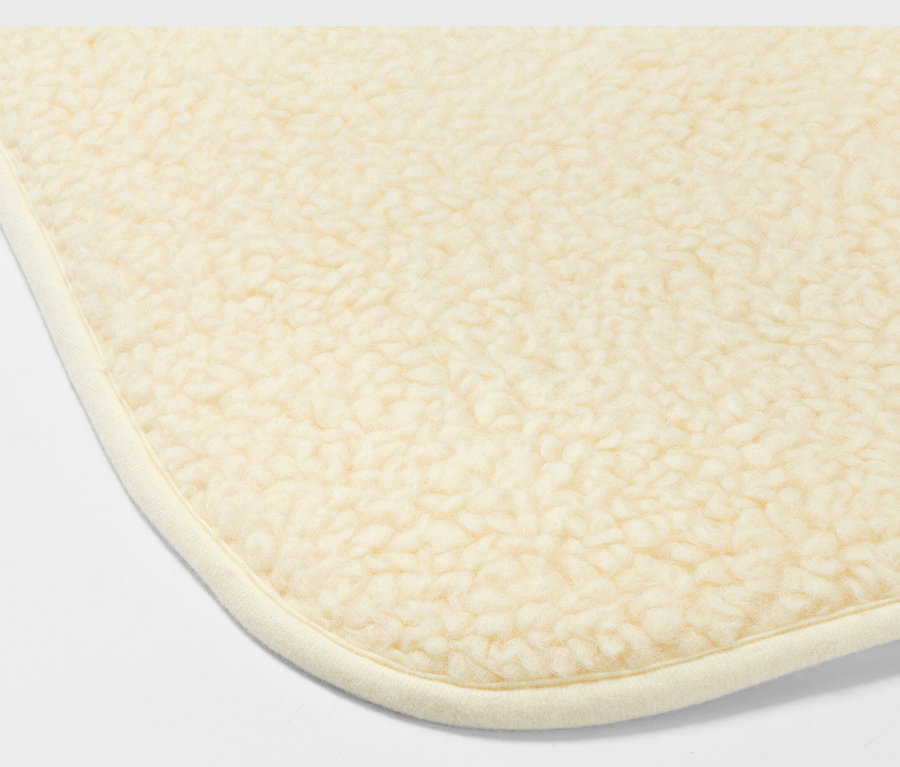 Detail einer Ecke der beigen Yogamatte mit Schurwolle.