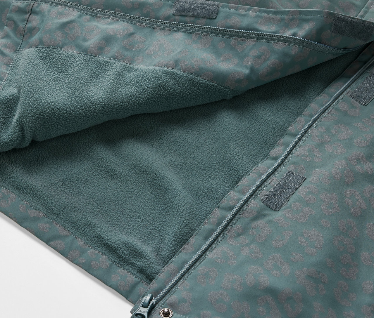 Detailansicht einer geöffneten Kinder-Thermo-Regenjacke mit reflektierenden Elementen, die das Innenfleece zeigt.