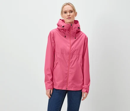 Eine Frau trägt eine pinke Jacke mit Kapuze und blaue Jeans.