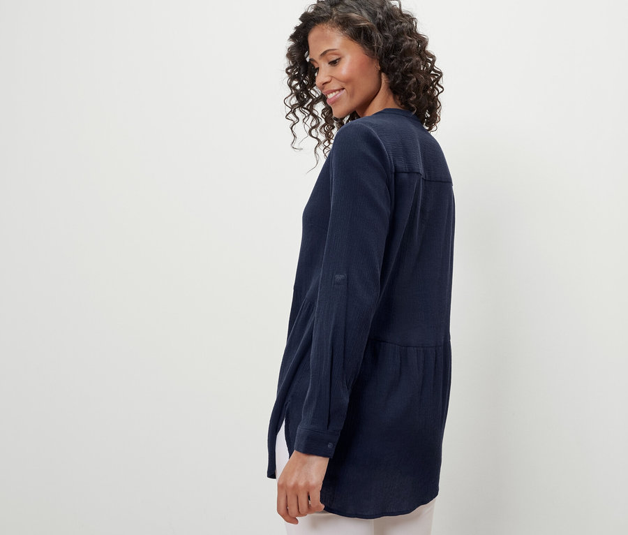 Frau trägt eine marineblaue Longbluse.