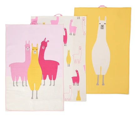 Drei Geschirrtücher liegen übereinander. Die Tücher sind rosa, gelb und weiß und mit Lamas bedruckt.